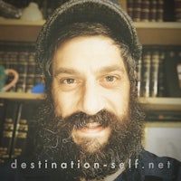 a man with a beard and hat in front of books